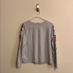 Gray sweatshirt with embroidered sleeves.